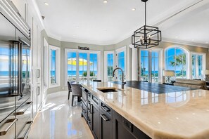A spacious kitchen with a large island, modern appliances, and a view of the ocean. - 33 Dune Lane- Oceanfront & Beautiful! (Hilton Head Island)