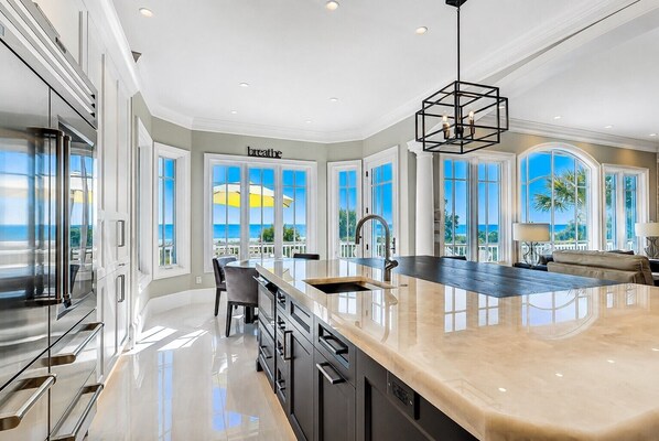 A spacious kitchen with a large island, modern appliances, and a view of the ocean. - 33 Dune Lane- Oceanfront & Beautiful! (Hilton Head Island)