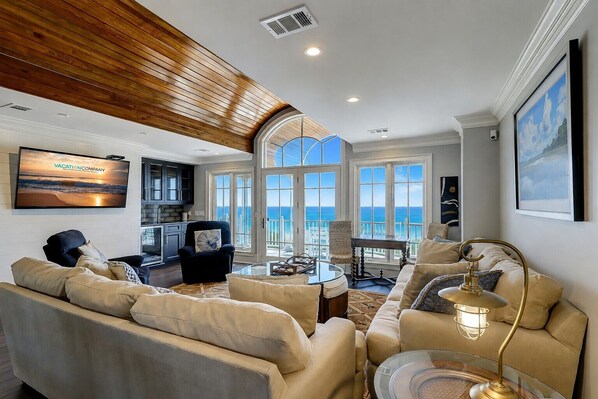 A spacious living room with a view of the ocean, a television, and a dining area. - 33 Dune Lane- Oceanfront & Beautiful! (Hilton Head Island)