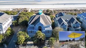 A coastal property with a large house featuring a garage, surrounded by palm trees and a view of the beach. - 33 Dune Lane- Oceanfront & Beautiful! (Hilton Head Island)