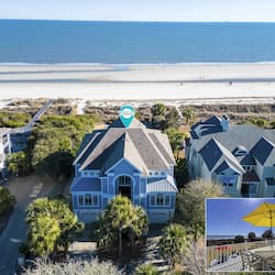 Enjoy ocean access from this serene beachfront property, featuring a spacious two-story house with a gabled roof and driveway.