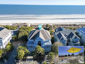 A coastal property with a large house featuring a garage, surrounded by palm trees and a view of the beach. - 33 Dune Lane- Oceanfront & Beautiful! (Hilton Head Island)