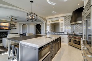 A modern kitchen with a large island, stainless steel appliances, and a sleek design. - 33 Dune Lane- Oceanfront & Beautiful! (Hilton Head Island)