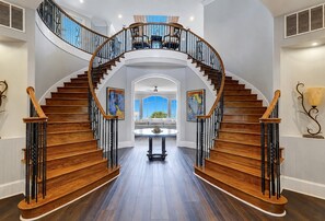 A grand staircase with a curved design, leading to a second floor.