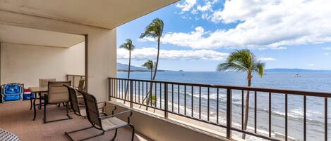 Ein Balkon mit Blick auf den Ozean, Palmen und einen Strand.
