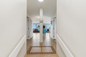 Un pasillo con piso de baldosas que lleva a una habitación con vistas.