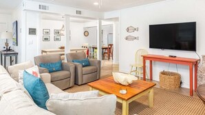 A living room with a sofa, coffee table, and television. - Bikini Bottom | Charming Apt in Historic Home, Nearby Beach Access (Tybee Island)