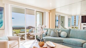 Un salon moderne avec un canapé, une table basse et une vue sur l’extérieur.