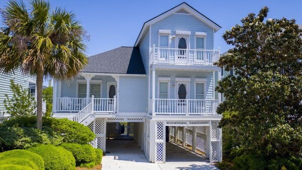 A two-story house with a balcony, a covered porch, and a staircase leading to the entrance.
