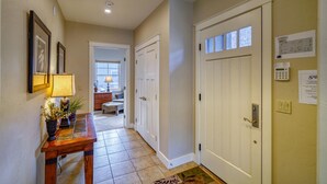A hallway with a wooden bench, a lamp, and a door with a keypad lock.