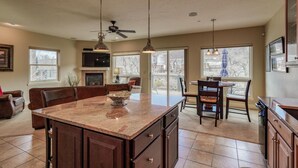 A spacious kitchen with a large island, built-in cabinets, and pendant lighting.