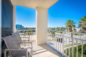 Enjoy the urban view from this balcony with a clear view of palm trees, a road, and distant buildings.