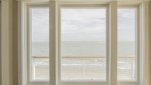 Una ventana con vista al océano y a la playa.