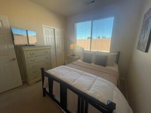 Cozy retreat with a comfortable bed, dresser, and mirror.