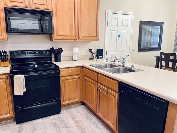 Kitchen features a stove, microwave, and dishwasher, with ample storage and a spacious countertop for meal preparation.