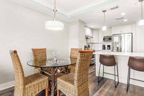 A modern kitchen with white cabinets, stainless steel appliances, and a central island. - Ocean Song 332 | Oceanfront, Amazing Views! (Tybee Island)