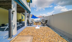Un patio exterior con mesa de billar, sillas y una chimenea.