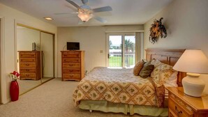 A bedroom with a bed, dresser, and a ceiling fan.
