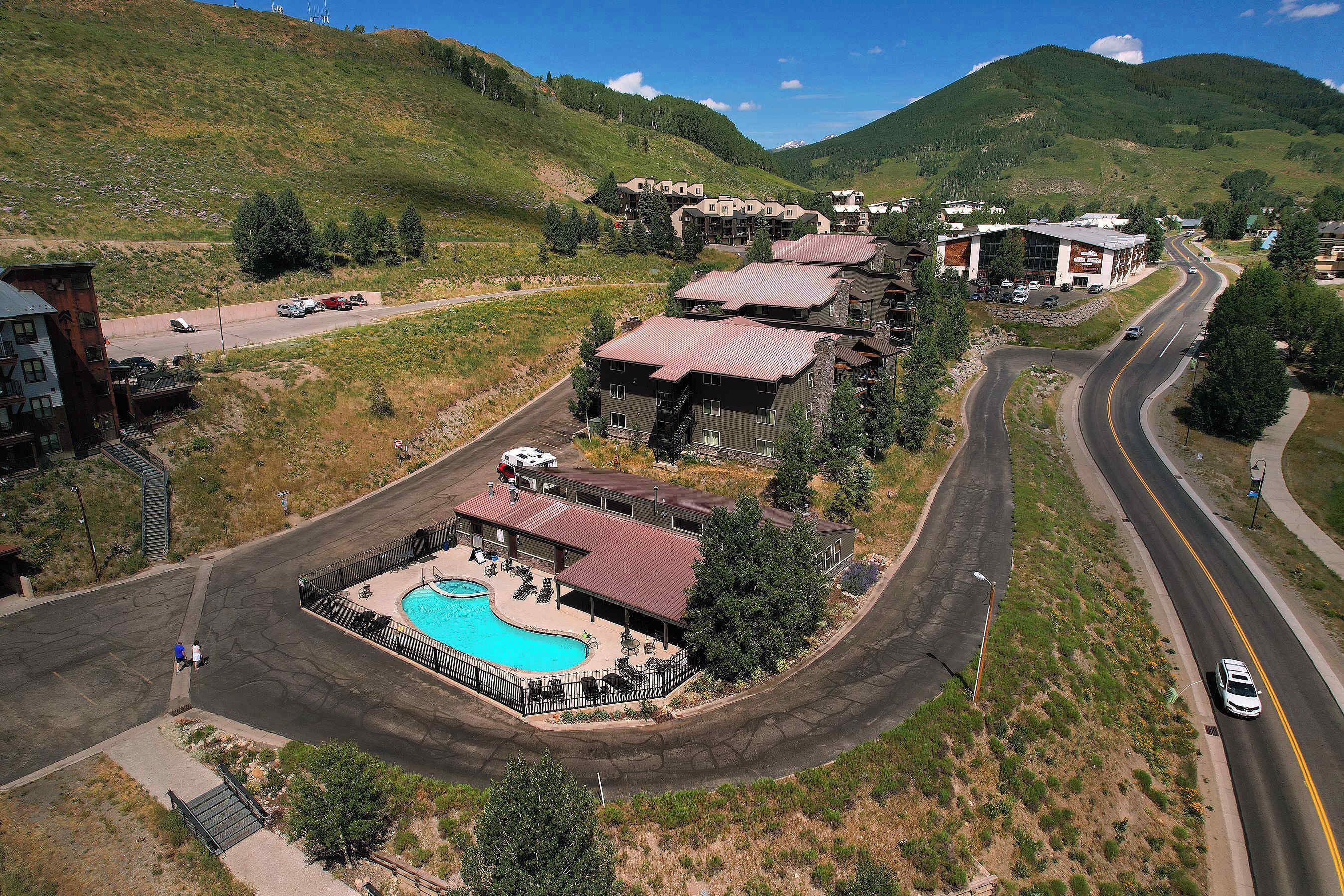 Un hôtel doté d’une piscine, de plusieurs bâtiments et d’une route qui serpente à travers le domaine.
