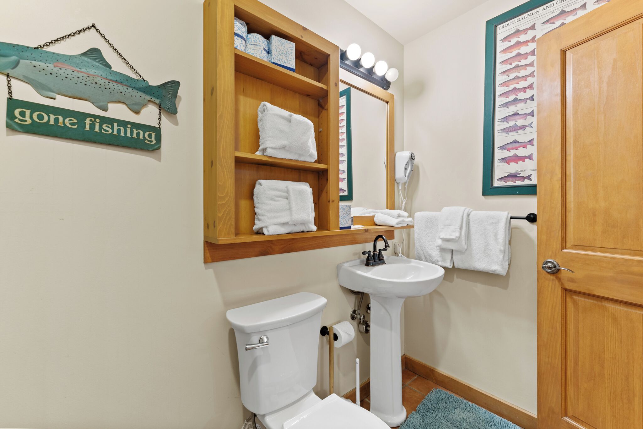 Your charming fishing-themed bathroom features crisp white linens and playful nautical decor for a refreshing morning routine.