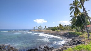 A beach with clear water, palm trees, and a rocky shoreline. - Aloha Condos, Keauhou Kona Surf and Racquet Club, Condo 1-102, Oceanfront (Kailua Kona)