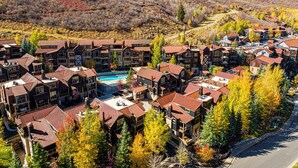 Un resort con diversi edifici, una piscina e montagne sullo sfondo.