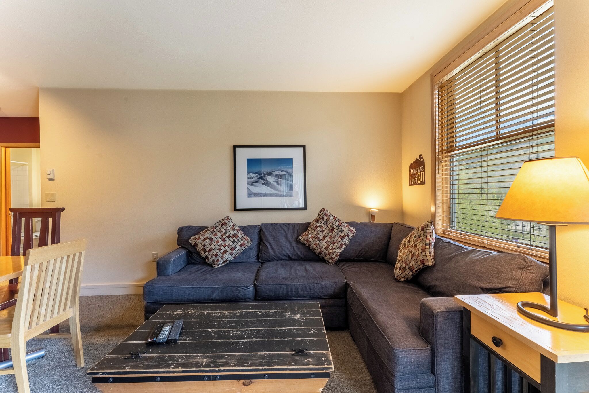 Settle into your cozy living space with a plush sectional sofa and warm lighting for the perfect evening retreat.