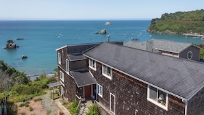 Une maison située sur la côte, avec vue sur la mer, dotée d’un balcon et d’un petit jardin.