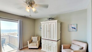 A room with a view of the beach, a white cabinet, two armchairs, and a coffee table. - Tybee Lights 112B | Pet Friendly, Incredible Views (Tybee Island)