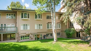Un bâtiment à deux étages doté d’un patio couvert, de nombreuses fenêtres et d’une pelouse bien entretenue.