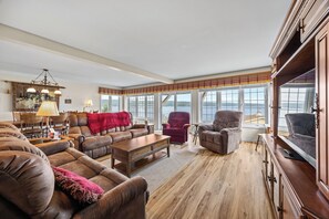 Un salon spacieux doté d’une grande fenêtre, d’une cheminée et d’un coin salon confortable.