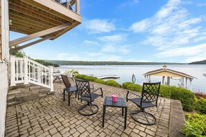 A patio with outdoor furniture overlooking a lake, a gazebo, and a view of the water.