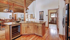 A spacious kitchen with wooden cabinets, a built-in oven, and a large island with a sink.