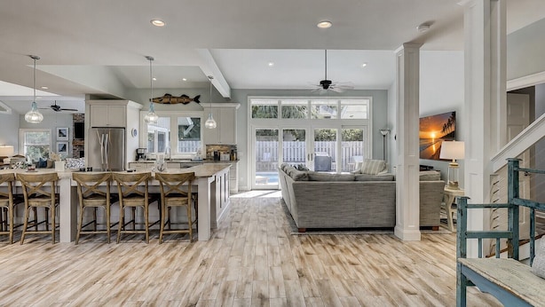A spacious kitchen with a central island, wooden flooring, and a view to the outdoors. - 5 Green Heron - 5th Row Ocean Home in Sea Pines (Hilton Head Island)