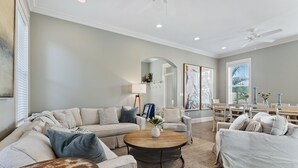 A spacious living room with a sectional sofa, a coffee table, and a dining area with a table and chairs.