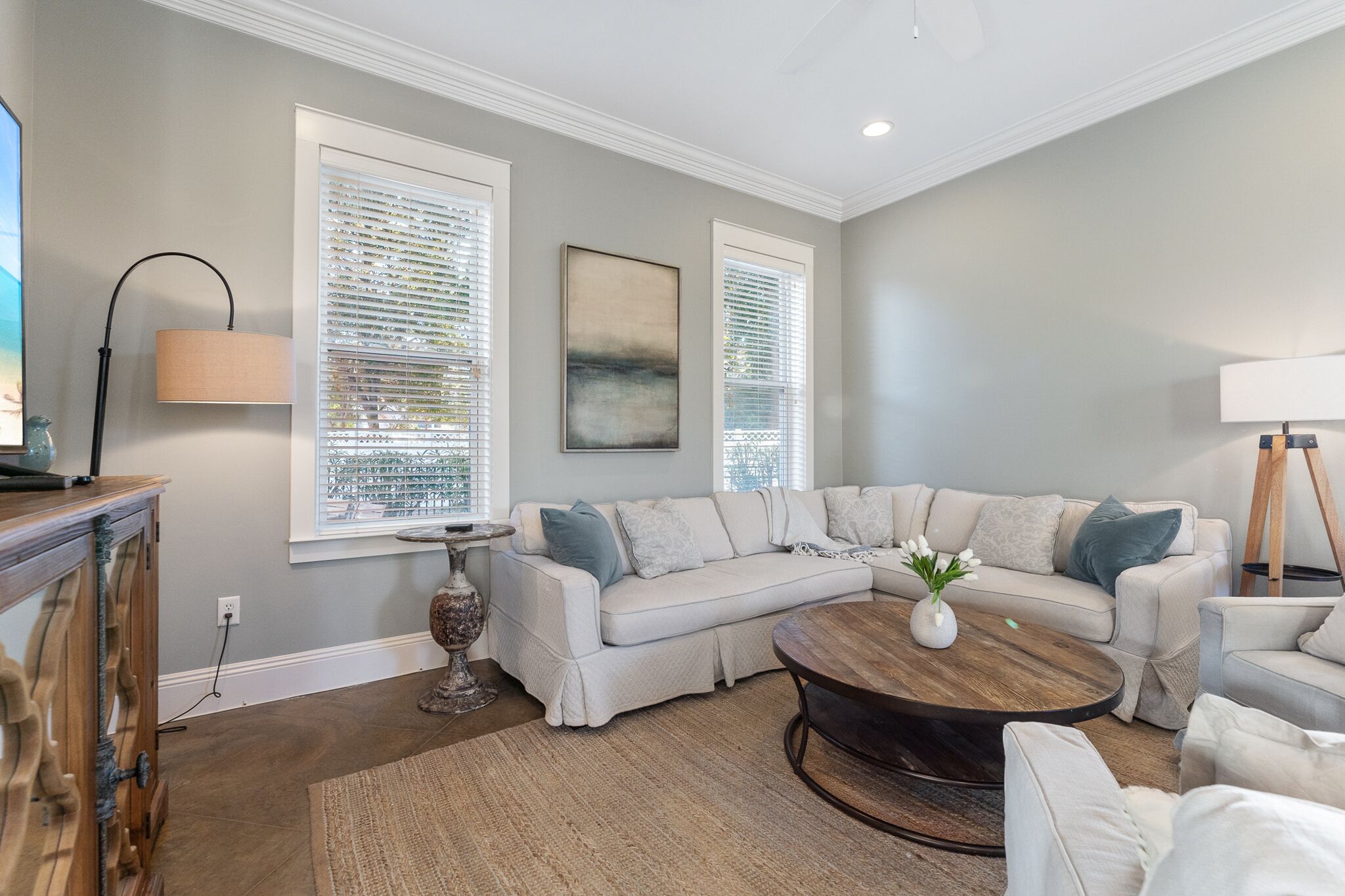 A modern living room with a sectional sofa, a coffee table, and a lamp.