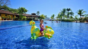 A pool area with a child on a colorful inflatable toy. - Ocean Front Luxury Condo, close to pool area! (Playa Herradura)