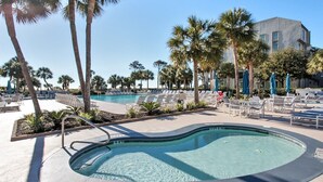A pool area with lounge chairs and palm trees. - Shorewood 103 - Oceanfront 1st Floor Condo (Hilton Head Island)