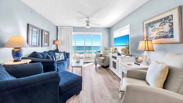 A spacious living room with a view of the ocean, a ceiling fan, and a dining area with a view. - Recently updated 2 bedroom-Beach Front Condo-Sleeps 6-Beach Service Included!! (Fort Walton Beach)
