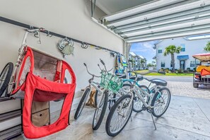 Un garaje con bicicletas y un bolso rojo colgado en la pared.