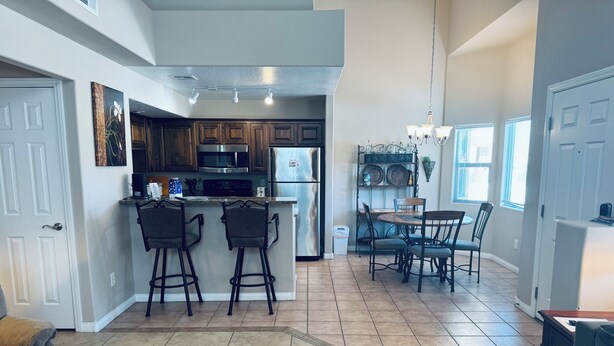 A spacious kitchen with a central island, bar stools, and a dining area with a round table and chairs.