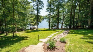 A pathway leading to a lake surrounded by trees.