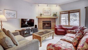 A cozy living room with a fireplace, a television, and comfortable seating. - Affordable Ski In/Out Mountain Oasis: Recent Updates, Easy Walk to Main St (Breckenridge)