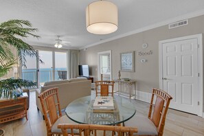 Enjoy a sea view from the balcony, featuring a dining table, sofa, and TV.