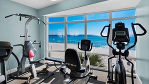 A gym with cardio machines and a view of the beach. - Affordable!Luxurious!BeachFront!TopFlrCondo!ReservedParking!Beach Service Included (Panama City Beach)