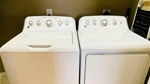 Dos lavadoras blancas de carga frontal en un cuarto de lavado.