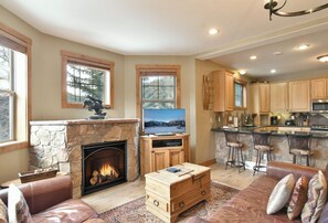 A cozy living room with a stone fireplace, a television, and a comfortable seating area. - Rachel Lane Home: Views, Style, Hot Tub (Breckenridge)