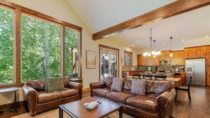 A spacious living room with leather sofas, a coffee table, and large windows with blinds. - Points West - Close to Bend w/Hot Tub AC, Golf, and Mt Bachelor, 4 Suites (Bend)