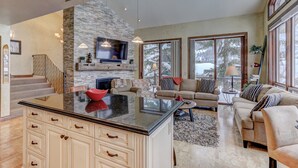 A spacious living area with a stone fireplace, a large TV, and a cozy seating arrangement. - Indulge in Luxury - Perfect for Groups with Private Hot Tub & Posturepedic Beds! (Park City)