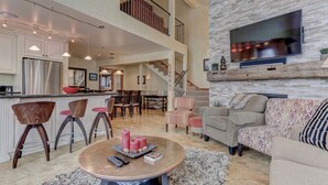 A spacious living area with a kitchen, dining space, and a staircase leading to an upper level. - Indulge in Luxury - Perfect for Groups with Private Hot Tub & Posturepedic Beds! (Park City)